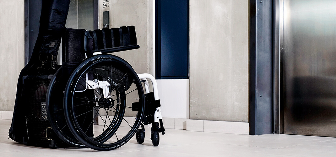 Handbewogen rolstoel opgevouwen voor transport.
