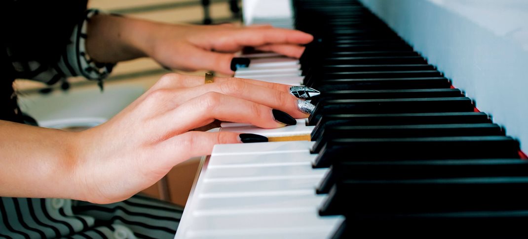 Vingers die de toetsen van een piano bespelen.
