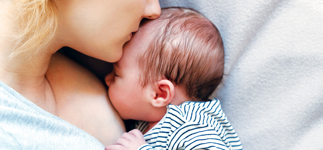 Een moeder die borstvoeding geeft aan haar pasgeboren baby.