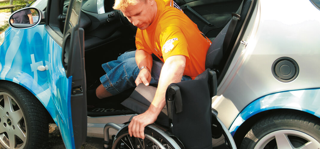 Een transfer maken van de rolstoel naar de autostoel.