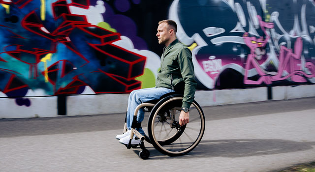 Man in een QUICKIE QS7 X rolstoel bij graffiti